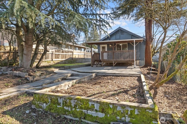 rear view of property with covered porch and fence