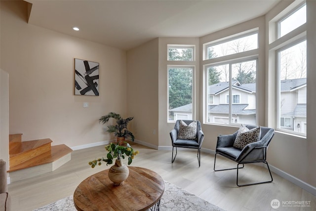 living area with baseboards and light wood finished floors