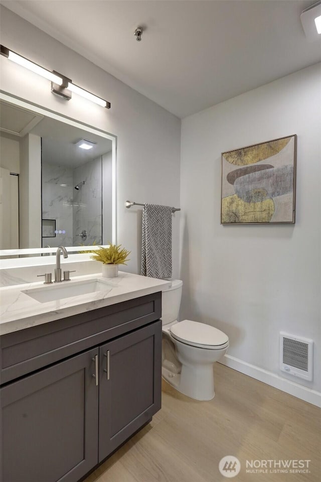 full bathroom with visible vents, toilet, baseboards, walk in shower, and vanity