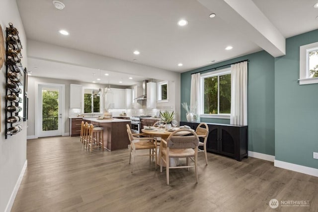 dining room with a wealth of natural light, light wood-type flooring, and baseboards