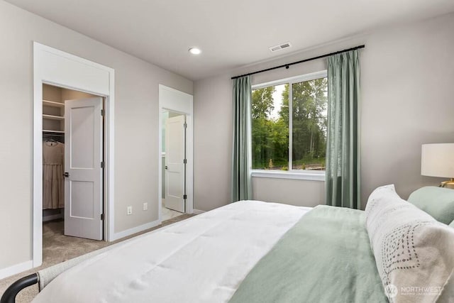 bedroom with baseboards, visible vents, carpet floors, recessed lighting, and a spacious closet