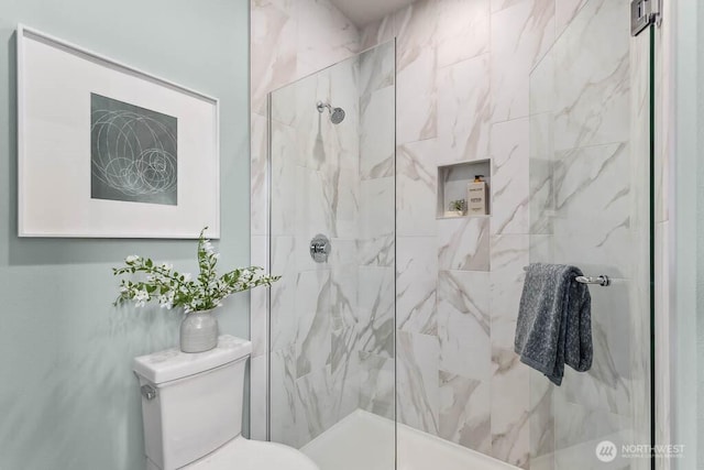 bathroom with a marble finish shower and toilet