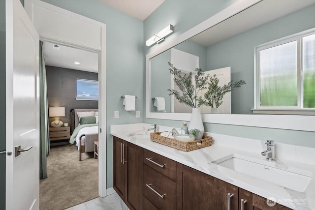 ensuite bathroom featuring double vanity, ensuite bath, and a sink