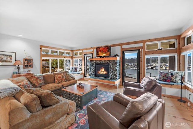 living room featuring a fireplace, light wood-style floors, and baseboards