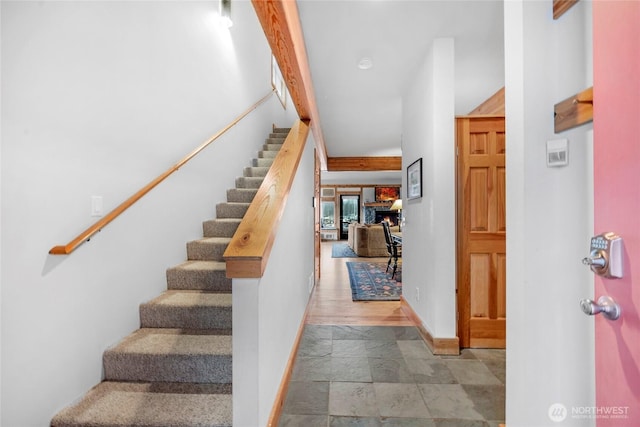 stairway with stone finish floor and baseboards