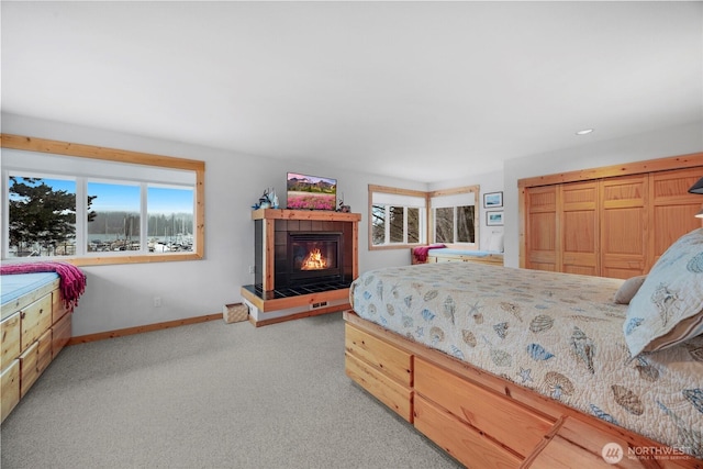 bedroom featuring carpet flooring, baseboards, and a tile fireplace