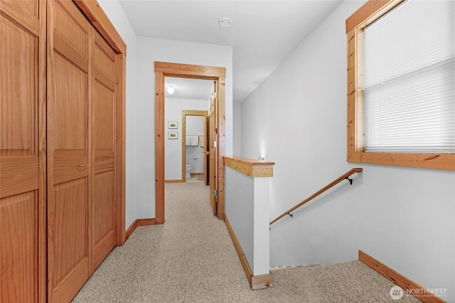 hall featuring baseboards and an upstairs landing