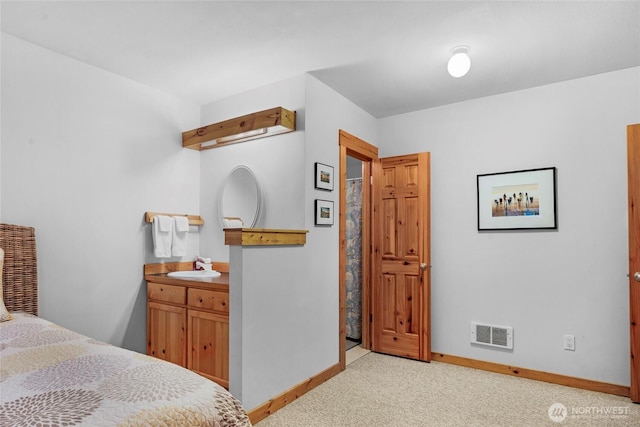 bedroom featuring light carpet, visible vents, baseboards, and a sink