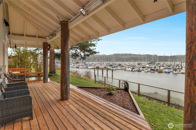 wooden deck with a yard and a water view