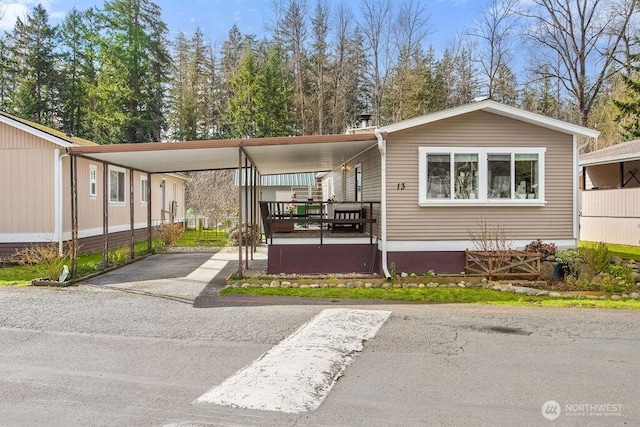 manufactured / mobile home featuring an attached carport and driveway