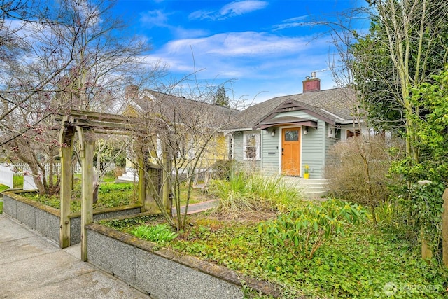 view of front of property with a shingled roof and a chimney