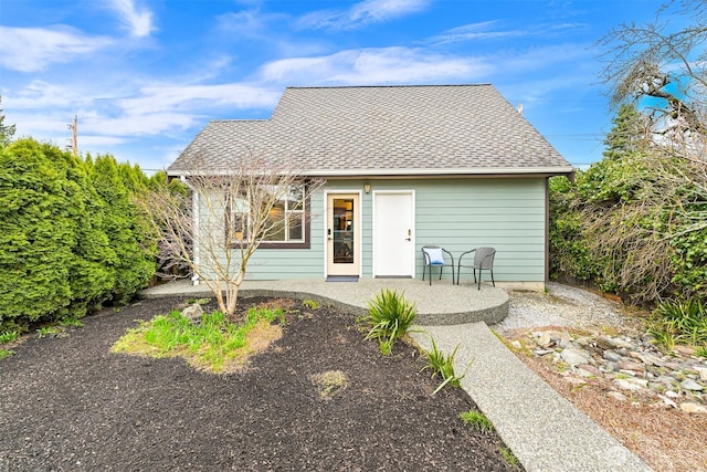 back of house with a patio and a shingled roof