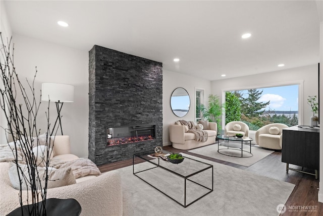 living room featuring recessed lighting, a fireplace, and wood finished floors