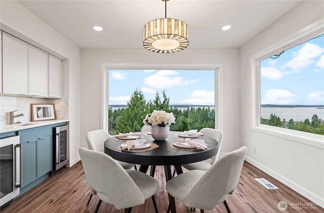 dining room with beverage cooler, visible vents, and a wealth of natural light