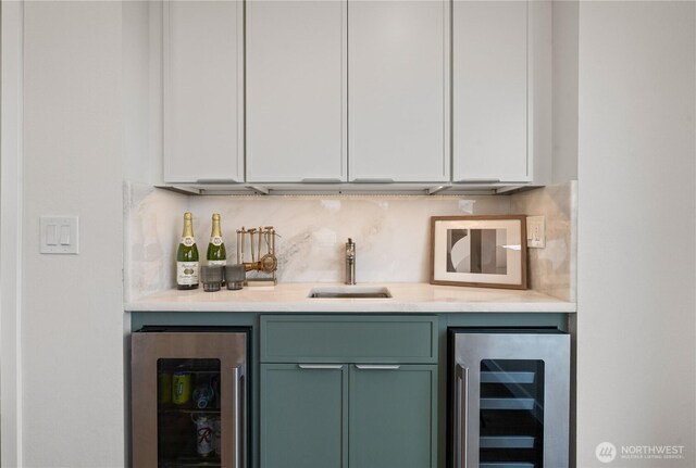 bar featuring a sink, indoor wet bar, tasteful backsplash, and beverage cooler