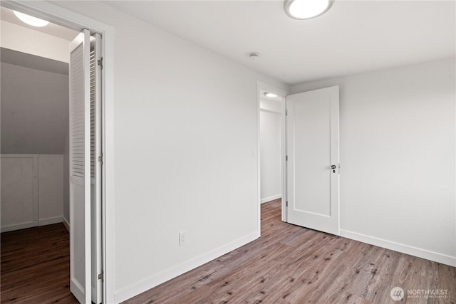 empty room with baseboards and wood finished floors