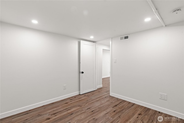 spare room featuring visible vents, recessed lighting, baseboards, and wood finished floors