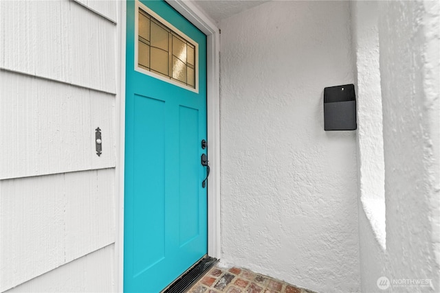 property entrance with stucco siding