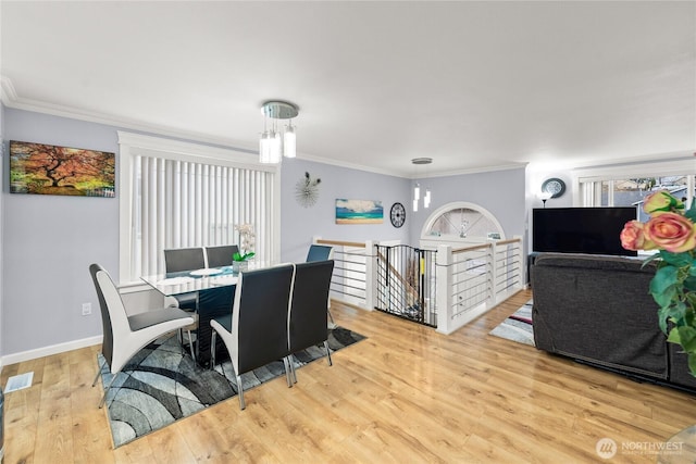 dining area featuring plenty of natural light, ornamental molding, and wood finished floors