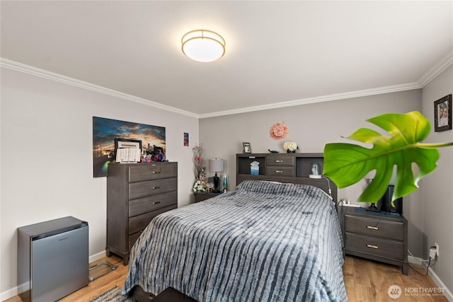 bedroom featuring crown molding, wood finished floors, and baseboards