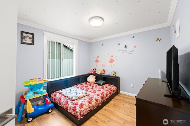 bedroom with wood finished floors and ornamental molding