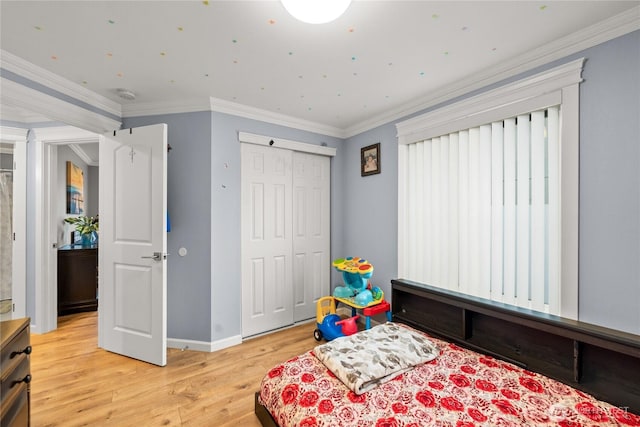 bedroom with a closet, light wood-type flooring, baseboards, and ornamental molding