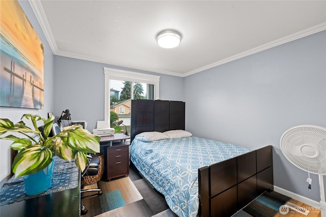 bedroom featuring baseboards, wood finished floors, and ornamental molding