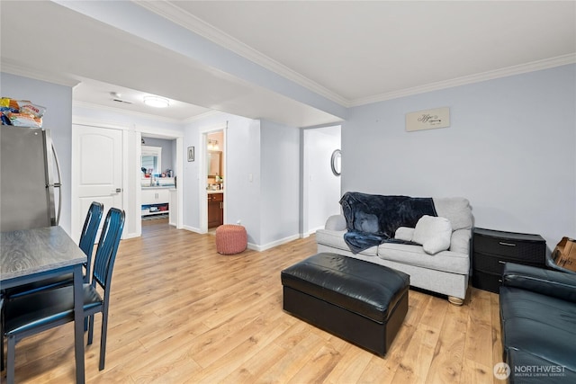 living area featuring baseboards, light wood-style floors, and ornamental molding