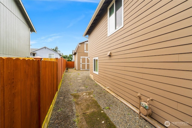 view of side of property with an outdoor structure and fence