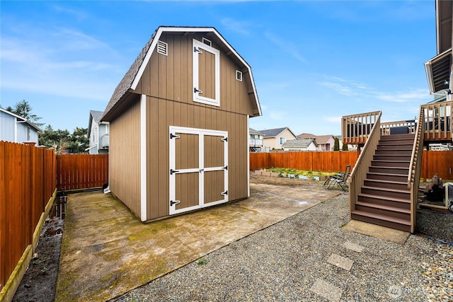 view of shed featuring stairway and a fenced backyard