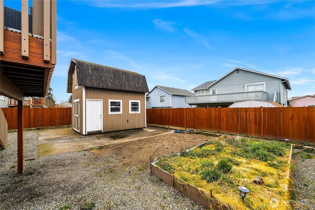 view of yard with an outdoor structure, a vegetable garden, a storage unit, and a fenced backyard