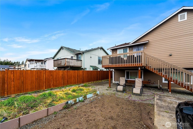 view of yard with fence, stairway, a residential view, a deck, and a garden