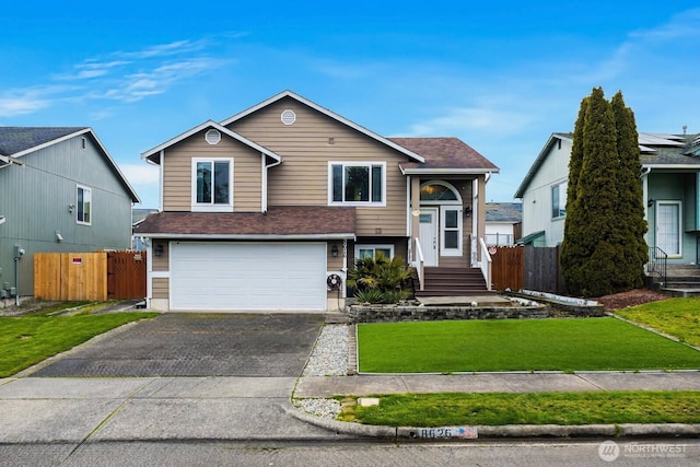 view of front of house featuring driveway, fence, a front yard, a shingled roof, and a garage