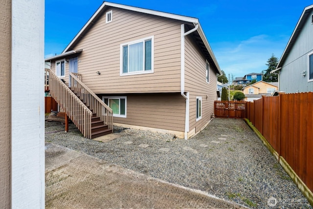 back of house featuring stairs and fence