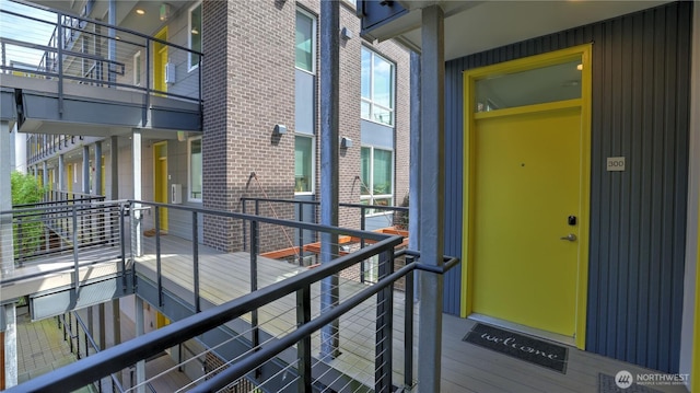 property entrance with brick siding and a balcony