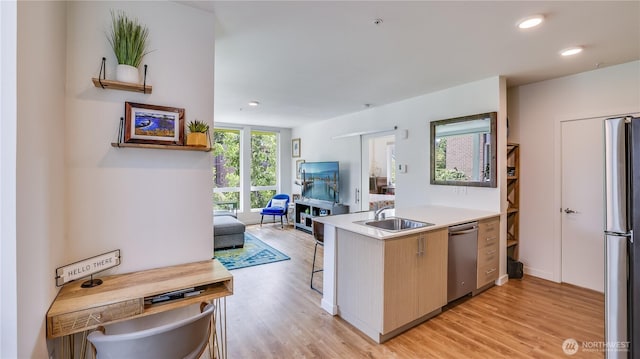 kitchen featuring light wood finished floors, recessed lighting, appliances with stainless steel finishes, and a sink