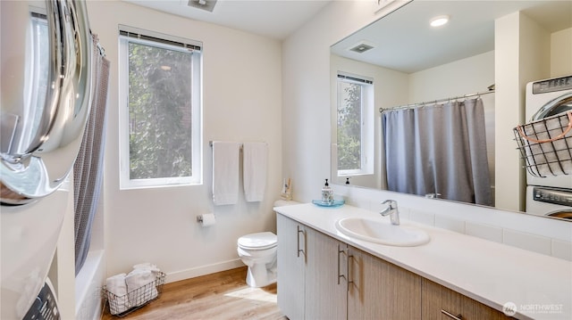 bathroom featuring plenty of natural light, toilet, and wood finished floors