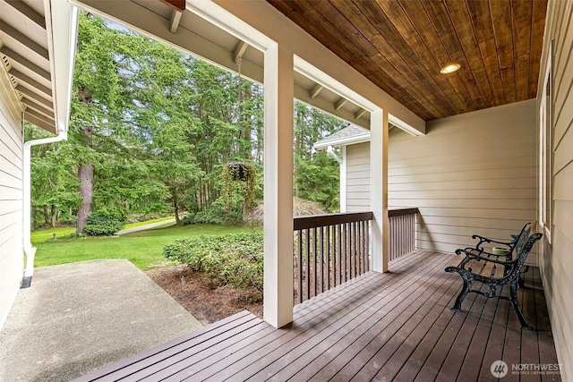 wooden deck with a yard and a patio