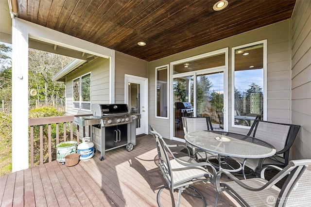 wooden deck featuring outdoor dining area and a grill