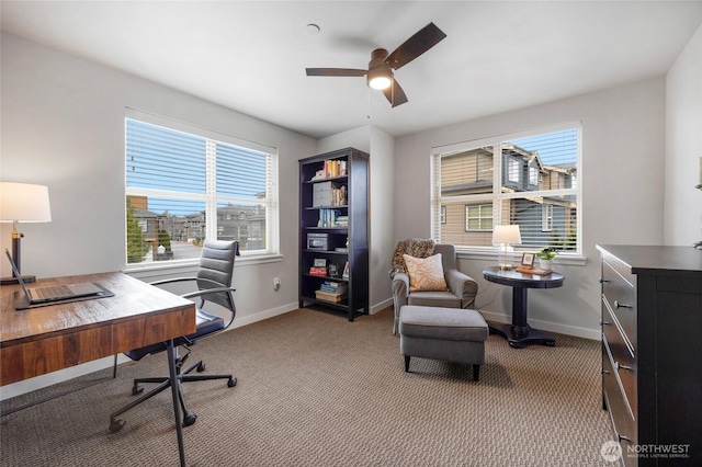 carpeted office featuring baseboards and a ceiling fan