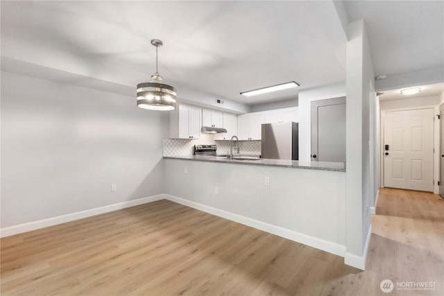 kitchen featuring electric range, under cabinet range hood, tasteful backsplash, fridge, and white cabinets