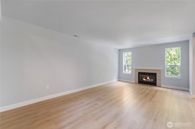 unfurnished living room with light wood-style flooring, visible vents, and baseboards