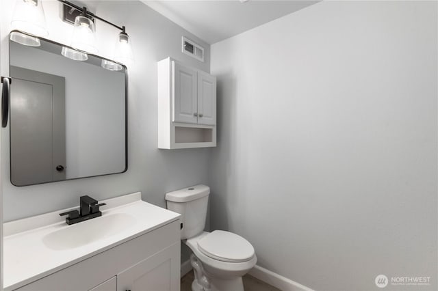 bathroom featuring vanity, toilet, baseboards, and visible vents