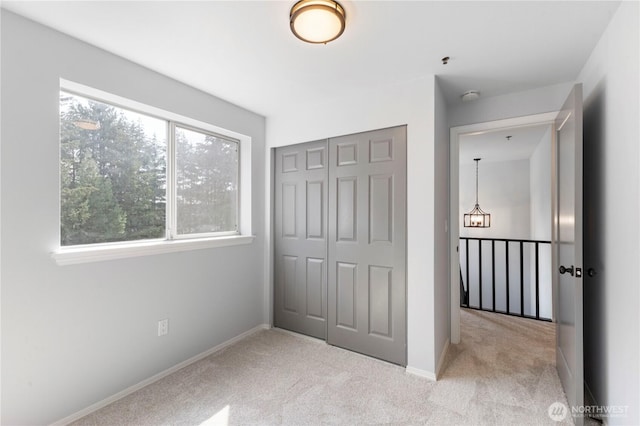 unfurnished bedroom with a closet, carpet floors, and baseboards