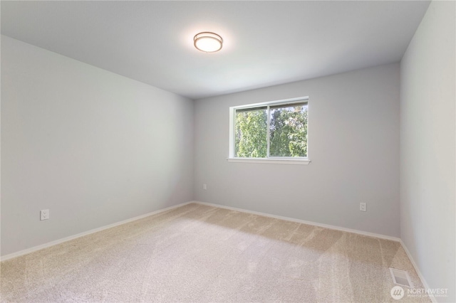 spare room with baseboards, visible vents, and light carpet