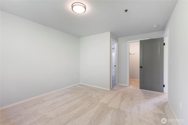 carpeted empty room featuring baseboards