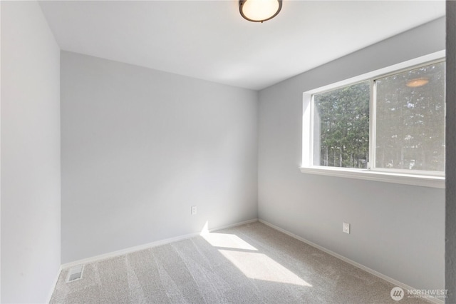 spare room featuring visible vents, carpet floors, and baseboards