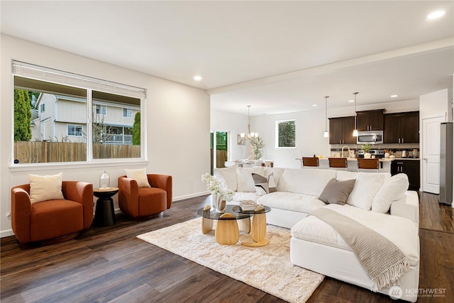 living area featuring recessed lighting, baseboards, an inviting chandelier, and dark wood-style flooring