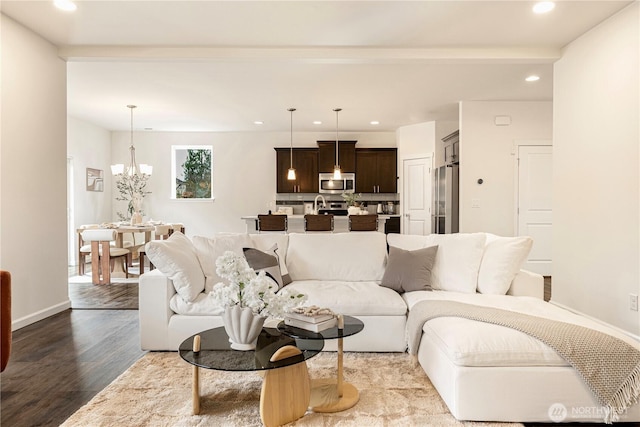 living area featuring recessed lighting, wood finished floors, baseboards, and a chandelier