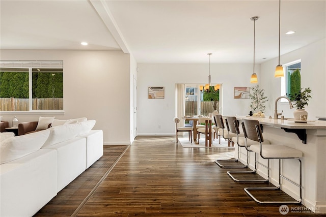 living area featuring a chandelier, recessed lighting, baseboards, and dark wood-style flooring